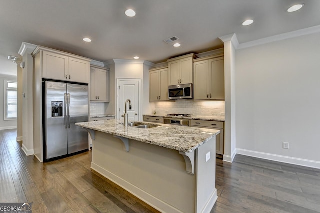 kitchen featuring stainless steel appliances, a kitchen island with sink, a sink, and ornamental molding