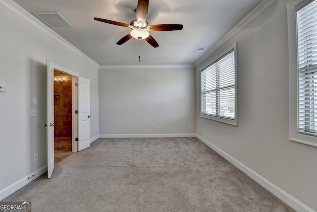 unfurnished bedroom featuring light colored carpet, ornamental molding, multiple windows, and visible vents