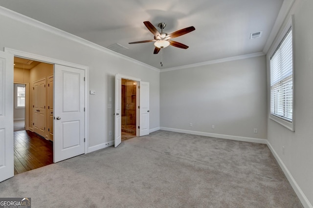 unfurnished bedroom with crown molding, visible vents, carpet flooring, and multiple windows
