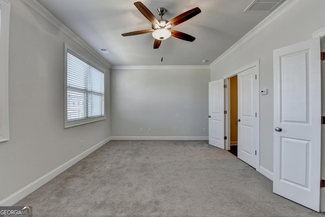 unfurnished bedroom featuring carpet flooring, baseboards, visible vents, and ornamental molding