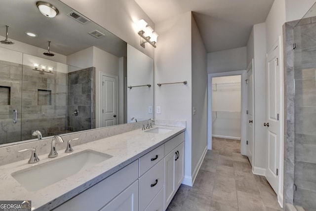 bathroom featuring a shower stall, a sink, and visible vents