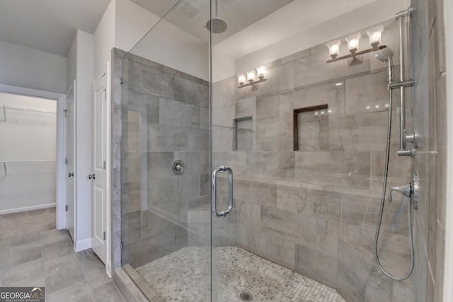 bathroom featuring a spacious closet and a stall shower