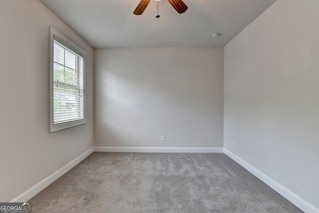 spare room featuring carpet, a ceiling fan, and baseboards