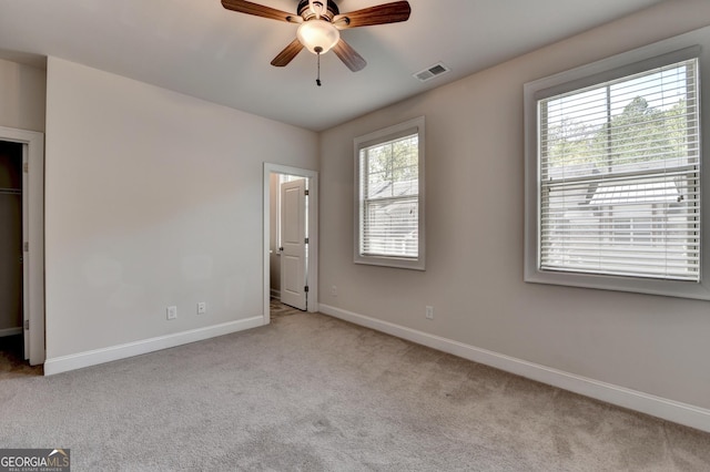 unfurnished bedroom featuring carpet floors, a ceiling fan, visible vents, and baseboards