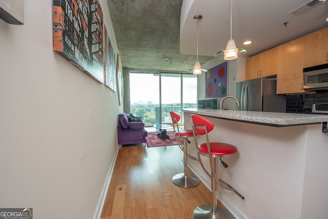 361 17th St NW Unit 1107, Atlanta, GA 30363 - kitchen featuring appliances with stainless steel finishes, light wood-type flooring, a breakfast bar, tasteful backsplash, and recessed lighting