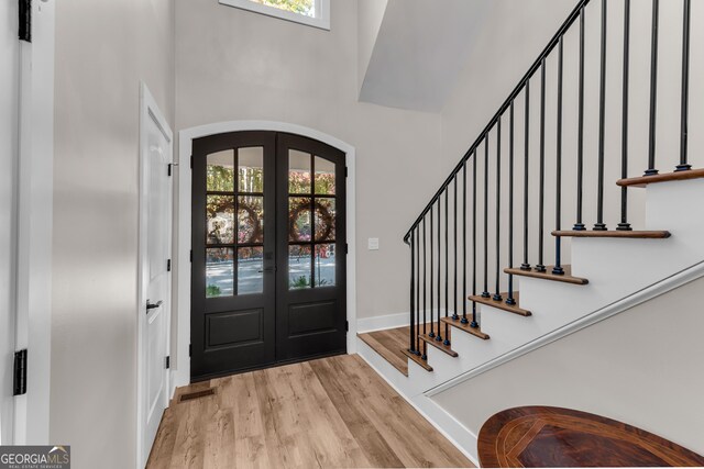 10005 Lakeview Pkwy, Villa Rica, GA 30180 - entryway featuring french doors, wood finished floors, plenty of natural light, arched walkways, and a towering ceiling