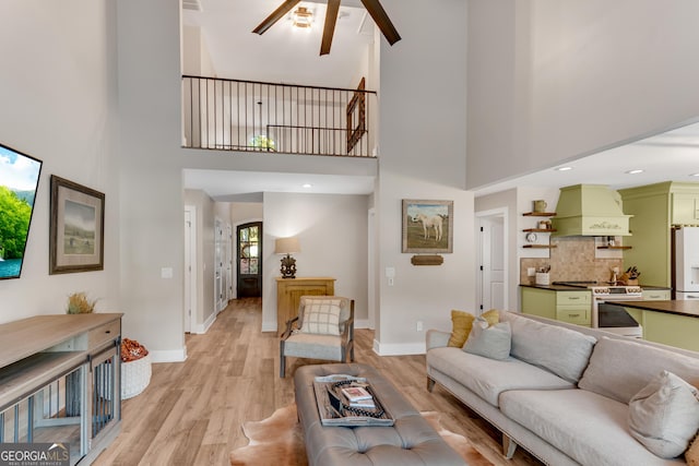 10005 Lakeview Pkwy, Villa Rica, GA 30180 - living area featuring a towering ceiling, ceiling fan, light wood finished floors, and baseboards