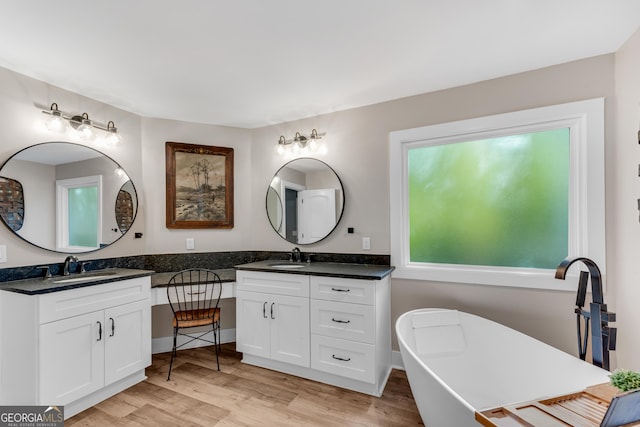 10005 Lakeview Pkwy, Villa Rica, GA 30180 - full bathroom with double vanity, wood finished floors, and a freestanding bath