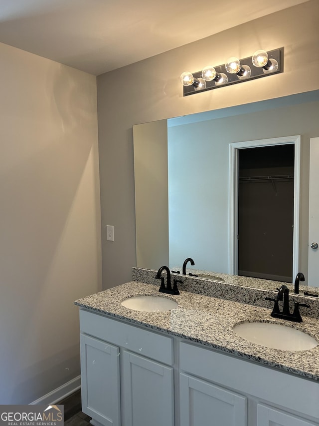full bath featuring double vanity and a walk in closet