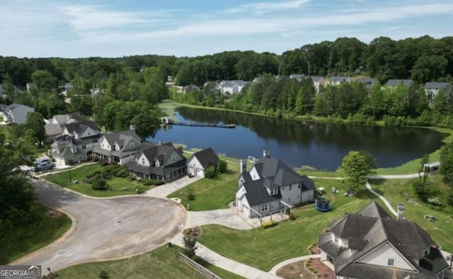 aerial view of property and surrounding area featuring a large body of water and a heavily wooded area