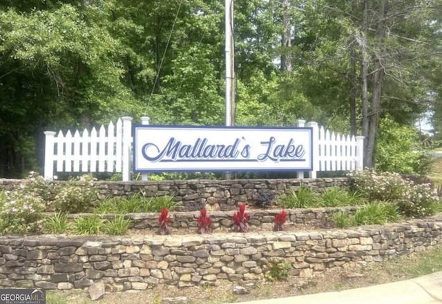 community sign featuring fence