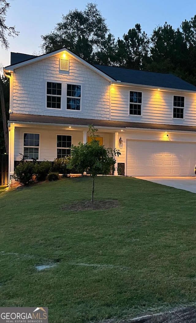 view of front of property featuring a garage, a front yard, and concrete driveway