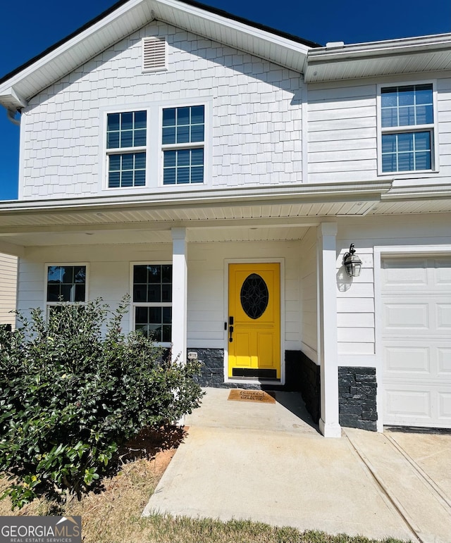 property entrance featuring a porch and stone siding