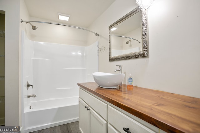 full bath featuring vanity, bathtub / shower combination, and wood finished floors