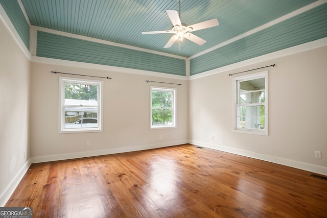 empty room featuring visible vents, ceiling fan, wood finished floors, and baseboards