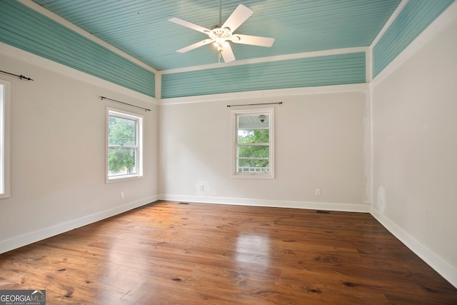 spare room featuring wood finished floors, a ceiling fan, visible vents, and baseboards