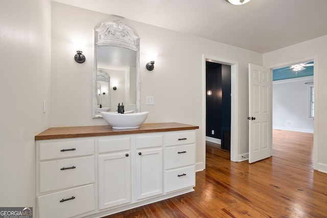 bathroom with vanity, wood finished floors, and baseboards