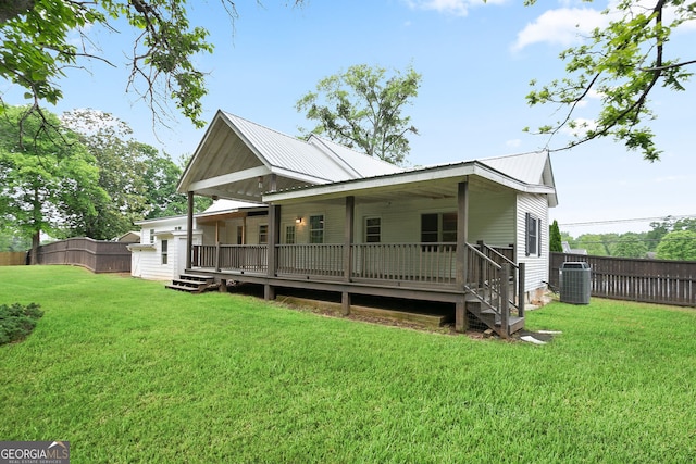 view of front of house featuring fence, metal roof, a wooden deck, central AC, and a front lawn