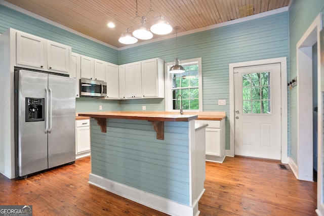 kitchen with appliances with stainless steel finishes, butcher block counters, white cabinets, and wood ceiling