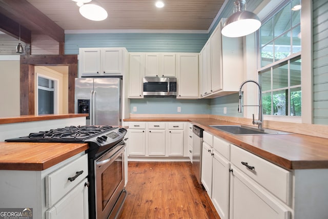 kitchen featuring wood ceiling, butcher block countertops, stainless steel appliances, and a sink