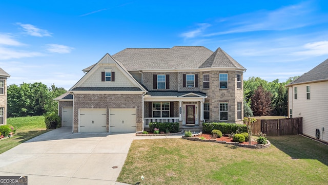 view of front facade with fence, concrete driveway, a porch, brick siding, and a front yard