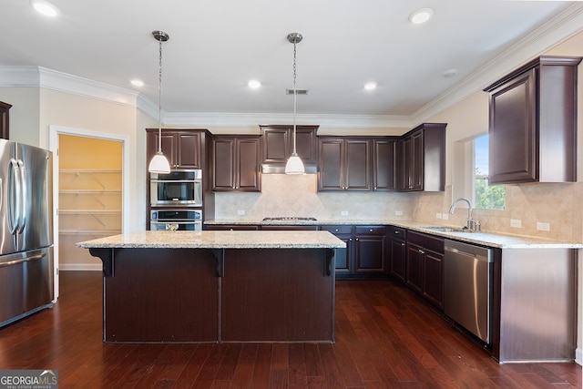 kitchen with a center island, dark brown cabinets, a sink, stainless steel appliances, and light stone countertops