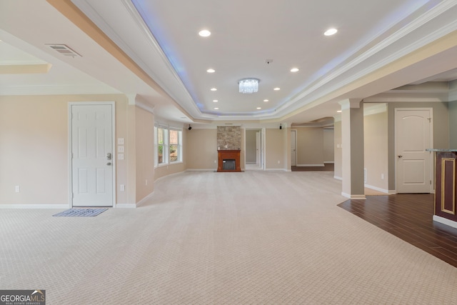 unfurnished living room with crown molding, a raised ceiling, baseboards, visible vents, and recessed lighting