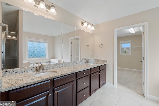 full bathroom with baseboards, tile patterned flooring, a sink, and double vanity