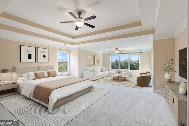 bedroom featuring ceiling fan, a tray ceiling, ornamental molding, and light colored carpet