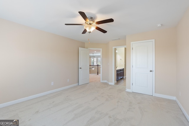unfurnished bedroom with visible vents, ensuite bath, baseboards, and light colored carpet