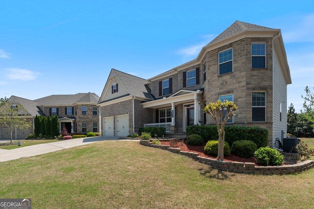 view of front of property with central AC unit, driveway, stone siding, a garage, and a front yard