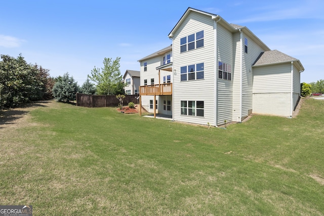 rear view of property with a yard and a deck