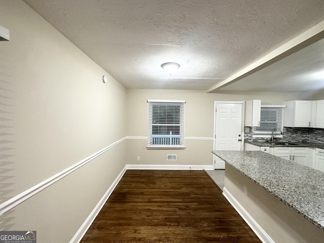2965 Meadowview Dr SE, Atlanta, GA 30316 - unfurnished dining area featuring dark wood-style floors, visible vents, a sink, baseboards, and a textured ceiling