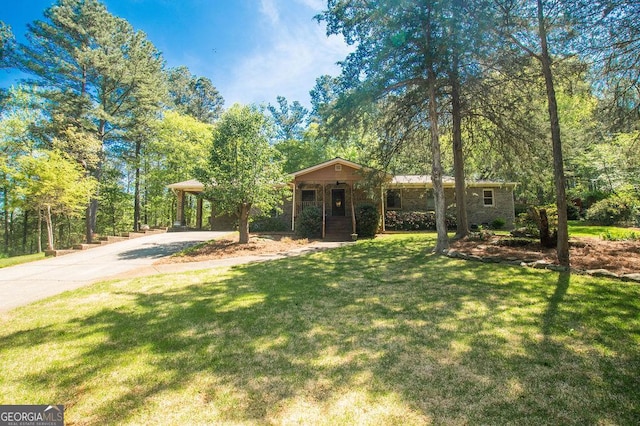 view of front of property featuring concrete driveway, a carport, and a front yard
