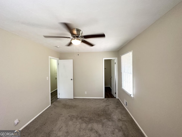unfurnished bedroom featuring ceiling fan, baseboards, visible vents, and carpet