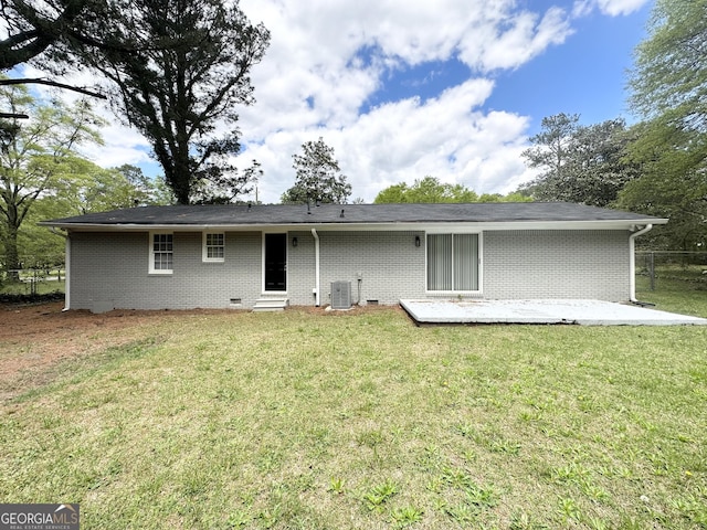 rear view of house featuring central AC unit, crawl space, fence, a yard, and brick siding