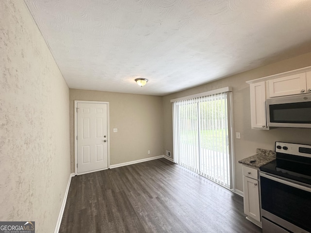 kitchen with white cabinets, stainless steel appliances, a textured wall, and dark wood-style flooring