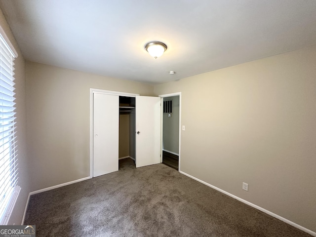 unfurnished bedroom featuring carpet floors, a closet, and baseboards