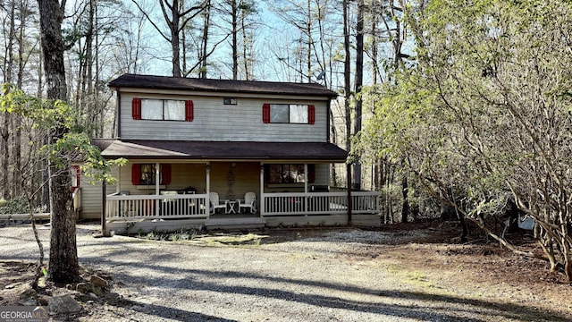 rustic home featuring a porch and driveway