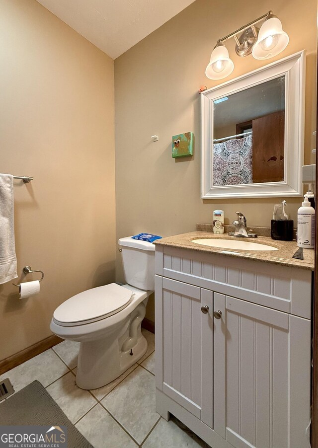 full bathroom featuring toilet, baseboards, tile patterned flooring, and vanity