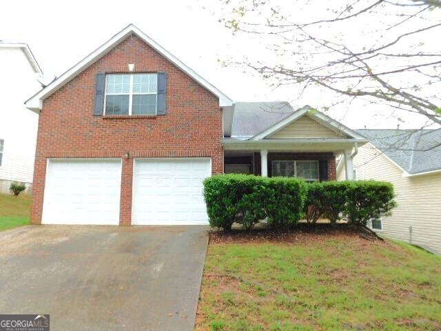 6991 Bonnes Blvd, Austell, GA 30168 - traditional home with an attached garage, driveway, and brick siding