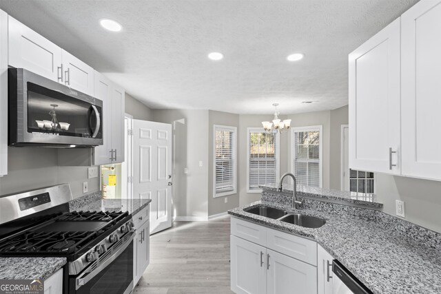 kitchen featuring a chandelier, appliances with stainless steel finishes, recessed lighting, and a sink