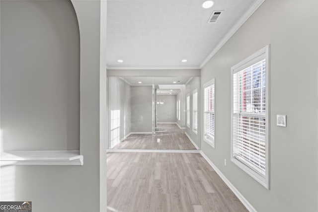 hallway with visible vents, baseboards, recessed lighting, wood finished floors, and crown molding