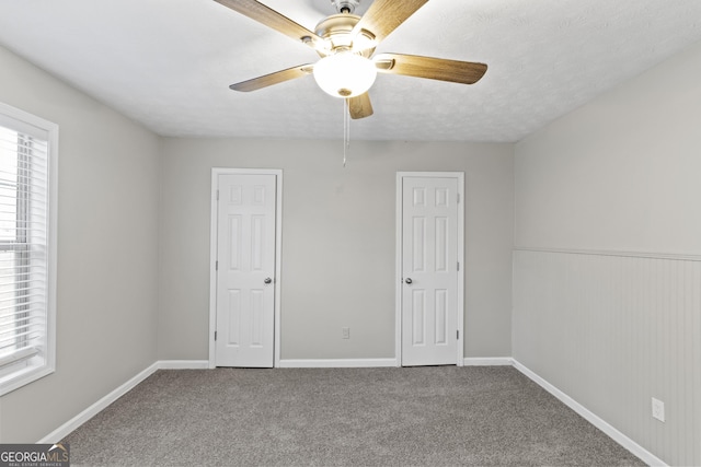 unfurnished bedroom with carpet flooring, baseboards, and multiple windows