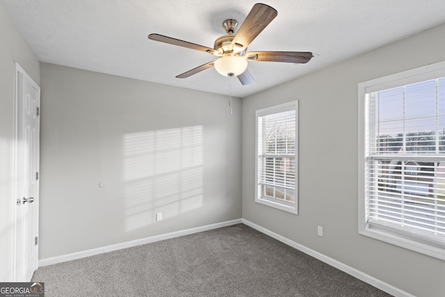 carpeted spare room with baseboards and ceiling fan
