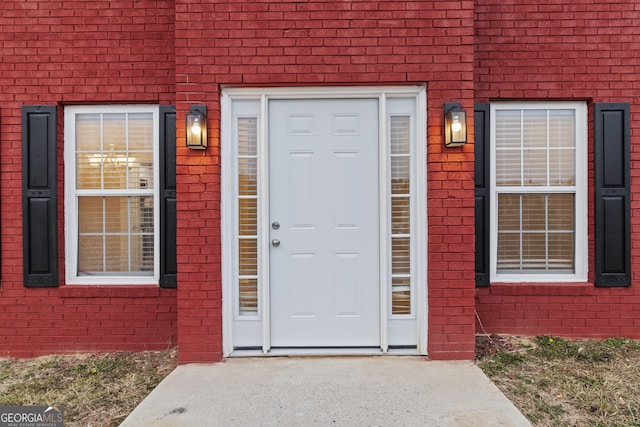 doorway to property featuring brick siding