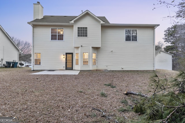 rear view of property featuring a patio area and a chimney