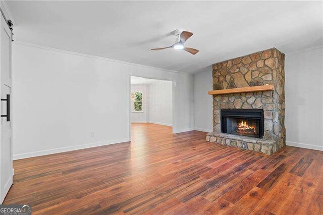 255 White Pines Dr, Alpharetta, GA 30004 - unfurnished living room featuring crown molding, a stone fireplace, wood finished floors, ceiling fan, and baseboards