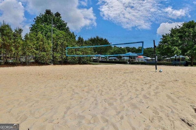 surrounding community with volleyball court and uncovered parking