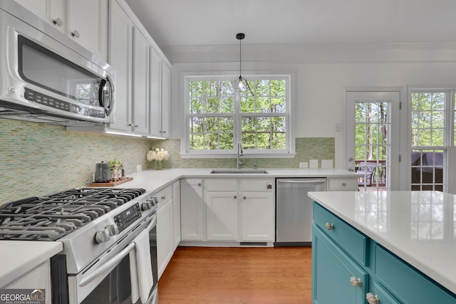 kitchen featuring light countertops, appliances with stainless steel finishes, white cabinetry, and a sink